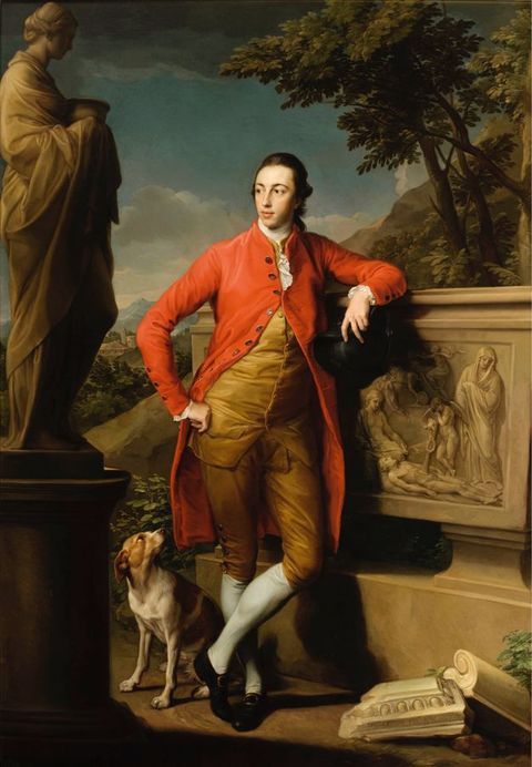 Painting. A pale-skinned, clean-shaven man with dark hair leans one elbow on the edge of a stone sarcophagus and looks off to our left, ankles crossed. The other hand, planted on his hip, holds back one side of his scarlet-red, knee-length coat.